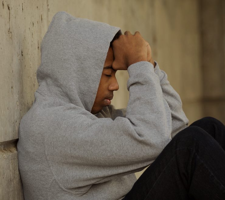 teen upset sitting concrete wall